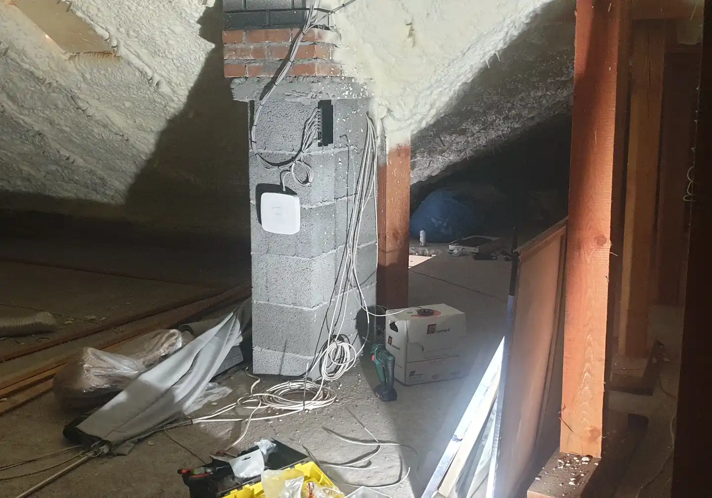 Widok ogólny na zamontowany system monitoringu IP Winkam – rejestrator i switch PoE estetycznie rozmieszczone na ścianie w dedykowanym punkcie technicznym.