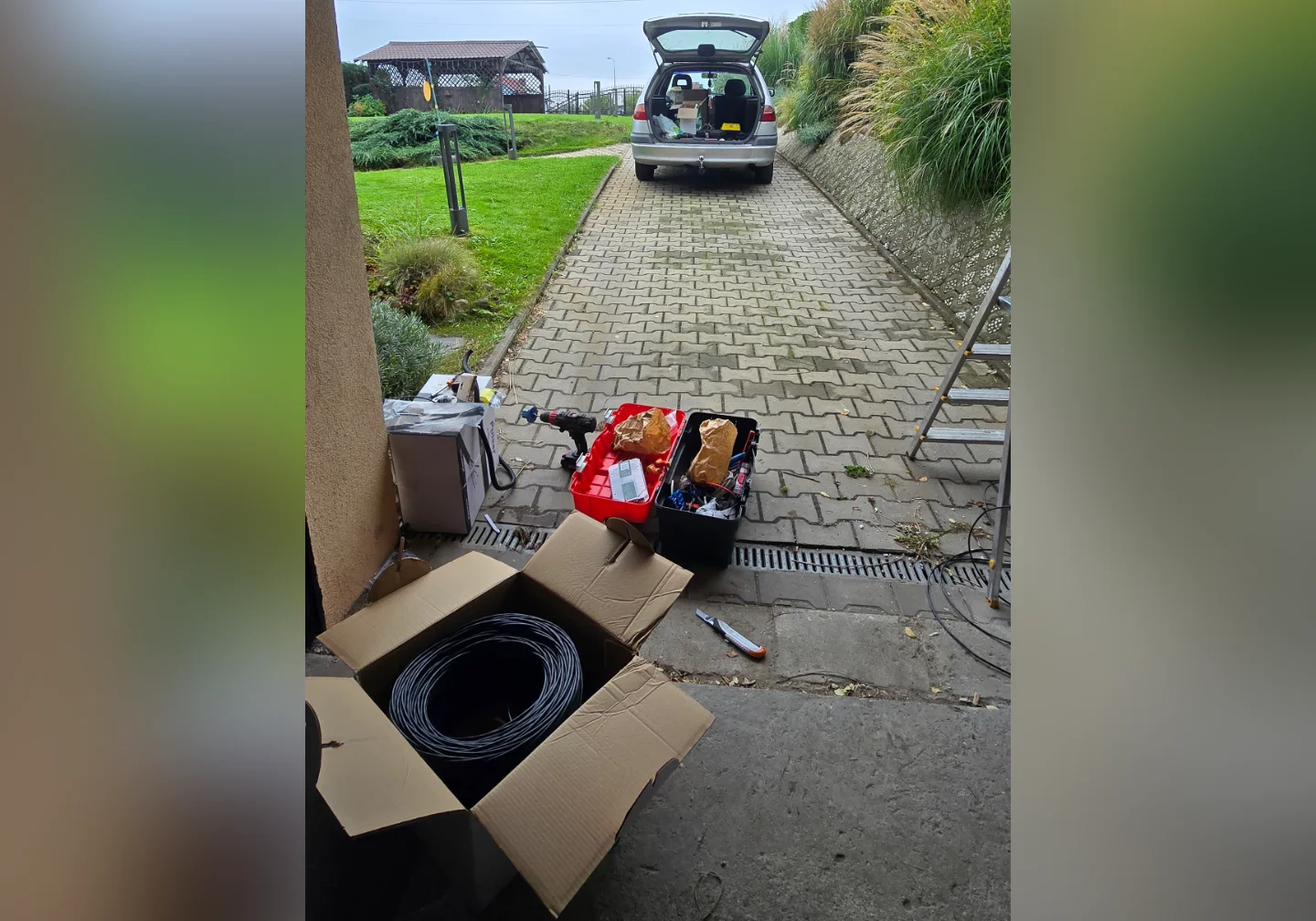 Stanowisko pracy Winkam: samochód firmowy, narzędzia, drabina i przygotowane okablowanie podczas montażu systemu ochrony w Rybniku.