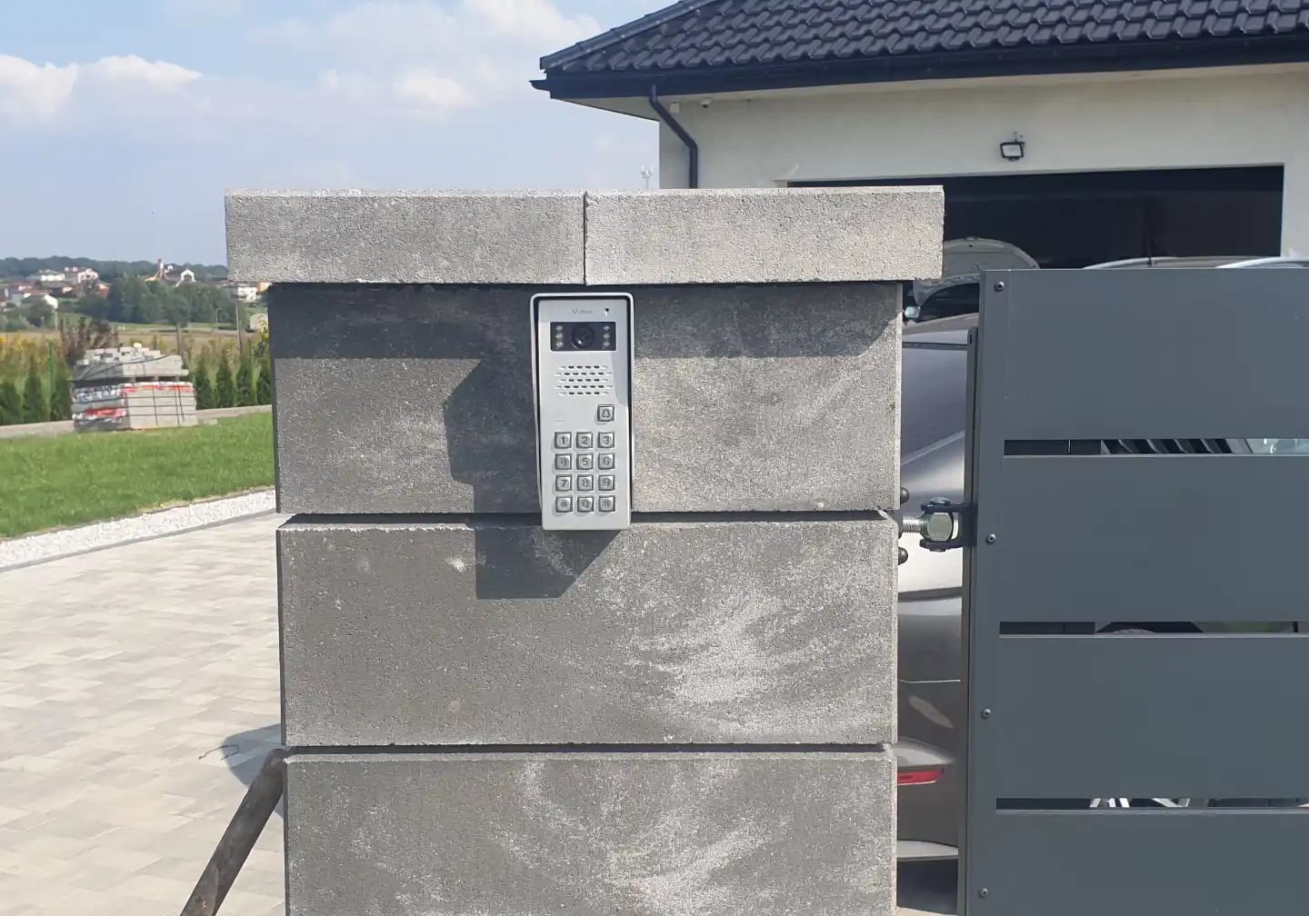 Stacja bramowa wideodomofonu Vidos z wbudowaną klawiaturą kodową zamontowana na metalowym słupku ogrodzeniowym – Winkam Rybnik.